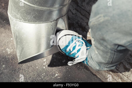 Adolescente in blu sneakers calci drainpipe, concetto di aggressione. Vintage la correzione delle tonalità, vecchio stile di effetto del filtro Foto Stock