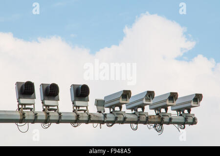 Quattro telecamere di sicurezza e cielo nuvoloso montata su palo di traffico Foto Stock