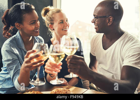 Etnia amici in un bar a bere vino e mangiare tapas Foto Stock