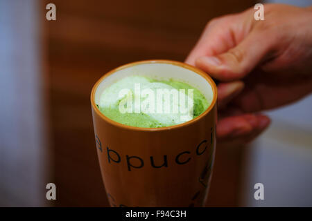 La miscelazione di colore verde erba d'orzo polvere in man mano. Succhi di frutta per la vitalità &amp;amp;amp;amp;amp; salute. Foto Stock