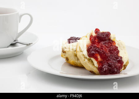 Inglese tradizionale tè alla crema di scones, clotted cream, confettura di fragole e una tazza di tè. Foto Stock