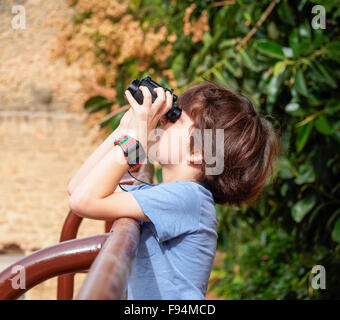 I giovani di osservazione degli uccelli un ragazzino di sette con un binocolo Foto Stock