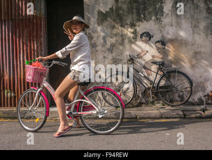 Turista che posano per una foto di fronte a una strada Arwotk dall artista lituano Ernest Zacharevic, Penang Island, George Town, Malaysia Foto Stock