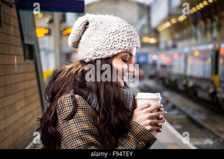 Bella giovane donna con tazza di caffè nella città Foto Stock