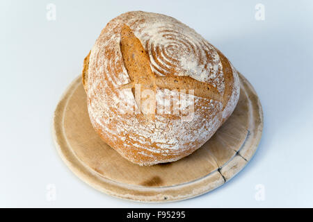 A casa appena sfornato pagnotta di pane di pasta acida su una breadboard Foto Stock