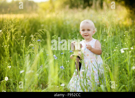 Estate outdoor ritratto di carino bambina sul prato soleggiato Foto Stock