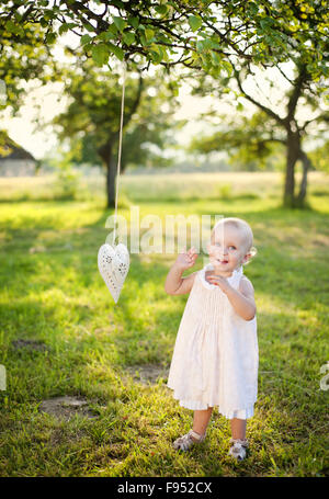 Estate outdoor ritratto di carino bambina nel giardino soleggiato Foto Stock