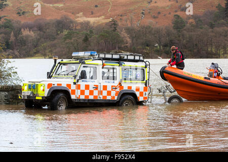 Sabato 5 dicembre 2015, Storm desmond si è schiantato nel Regno Unito, la produzione del Regno Unito più alto mai 24 ore totali di precipitazione a 341.4mm. Ha allagato il Lakeland Village Glenridding, che si stava appena cominciando a riparazione quando un altro periodo di heavy rain per mercoledì 9 dicembre hanno causato la Glenridding Beck di scoppiare le sue banche, provocando ulteriore distruzione. Questa foto scattata la mattina di venerdì 11 dicembre mostra Patterdale Mountain Rescue Team lanciando la loro barca di salvataggio, di prendere cibo alle Howtown sull'altro lato del lago che è stato tagliato per cinque giorni dalle inondazioni. Foto Stock