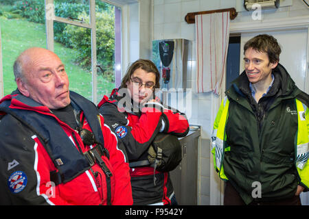 Rory Stewart, parlamentare Sotto Segretario di Stato presso il Ministero dell'ambiente, dell'alimentazione e gli affari rurali incontra i membri del Patterdale Mountain Rescue Team che offrono cibo alle vittime delle inondazioni in Howtown Hotel, che sono stati tagliati fuori dalle inondazioni da Storm Desmond. Foto scattata sul Venerdì 11 Dicembre 2015 Foto Stock