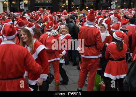 SantaCon Regno Unito. Babbo Natale clausole giovani umore natalizio d'incontro fuori dalla stazione di Liverpool Street, città centrale di Londra, Regno Unito 2015 2010s HOMER SYKES Foto Stock