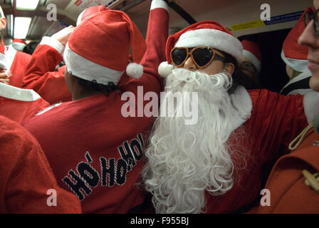 Babbo Natale con una grande barba falsa parte della nuova tradizione annuale SantaCon. Viaggio verso il luogo d'incontro dell'evento sulla metropolitana di Londra, HOMER SYKES degli anni '2015 2010 del Regno Unito Foto Stock