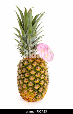 Ananas tropicale con ombrello rosa su sfondo bianco Foto Stock