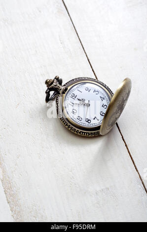 Antico orologio da tasca con catena contro rustico in legno invecchiato sfondo con mani quasi mezzanotte Foto Stock