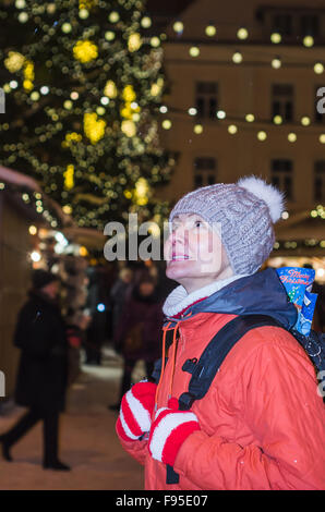 Una donna guarda al Natale decorati Piazza del Municipio di Tallinn Foto Stock