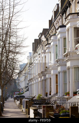 Hammersmith, Londra. Vista laterale di una strada residenziale foderato con case a schiera con finestre a bovindo e architettura Vittoriana. Foto Stock