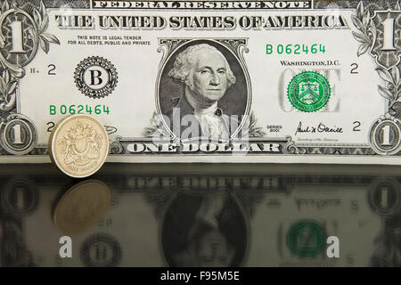American un dollaro Banca nota con uno britannico pound coin Foto Stock