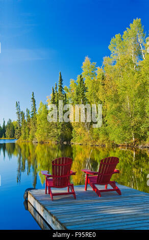 Poltrone Adirondack sul dock, MacKay Lago, northern Saskatchewan, Canada Foto Stock