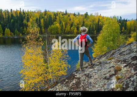 Escursionista sulla protezione Precambrian rock, Dickens Lago, Northern Saskatchewan, Canada Foto Stock