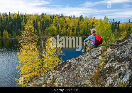 Escursionista sulla protezione Precambrian rock, Dickens Lago, Northern Saskatchewan, Canada Foto Stock