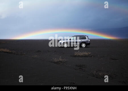 Quattro ruote auto di immersione nella caduta di cenere dal vulcano Eyjafjallajökull, con una perfetta rainbow in background Foto Stock