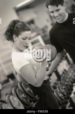 Caucasian maschi e femmine di sollevamento pesi nel fitness club (Modello rilasciato) Foto Stock