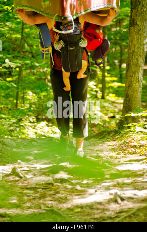 Una femmina di escursionista portages la canoa con un bambino, in vero Ontarian moda. Killarney Provincial Park Foto Stock