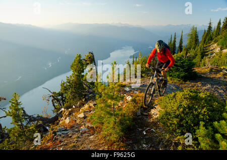 Un mountain biker scorre in alto sopra il lago di Kootenay in Purcell montagne della British Columbia Foto Stock