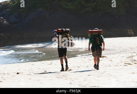 Due escursionisti di passeggiare lungo la spiaggia di San Jose Bay, alla ricerca di un campeggio per la notte. San Jose Bay. Foto Stock