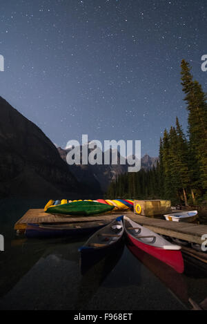 Canoe sul Lago Moraine di notte. Il Parco Nazionale di Banff, Alberta, Canada. Foto Stock