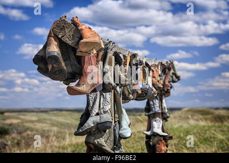 Vecchio stivali da cowboy di appendere in memoria di John Booth, grande Sandhills, vicino scettro, Saskatchewan, Canada Foto Stock