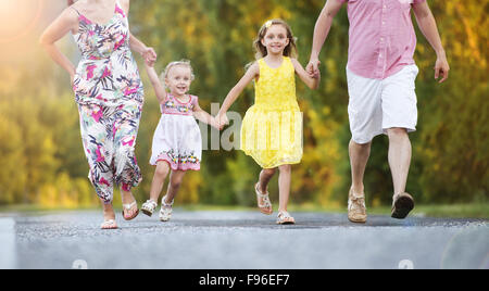 La famiglia felice avendo divertimento durante il cammino sulla strada Foto Stock