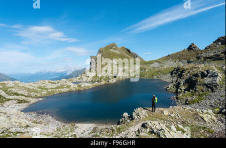 Hiker by a mountain lake, Rauhenbergsee mountain lake in Klafferkessel, Seenplatte, Rohrmoos-Untertal, Schladming Tauern, Styria Foto Stock