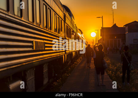 Sun Impostazione nella parte anteriore del treno passeggeri arrestato nella città di Melville in Saskatchewan, Canada. Foto Stock