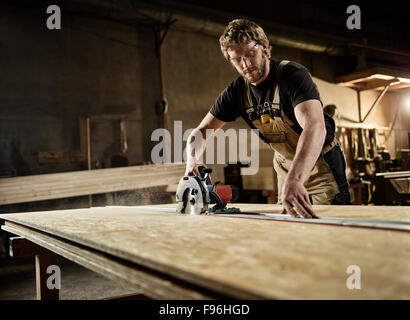 Carpenter truciolare di taglio con una sega circolare, Austria Foto Stock