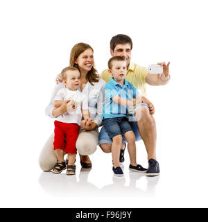Ritratto della famiglia felice con due bambini e madri incinte tenendo selfie, isolato su sfondo bianco Foto Stock