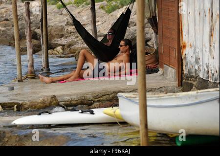 Coppia giovane relax su una amaca in una Casetes Varador vecchio boah house di Ibiza d'Eivissa Baleari Foto Stock