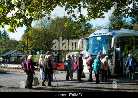 Un gruppo di anziani anziani turisti su una gita in pullman della Welsh attrazioni per i visitatori a tornare alle loro tour bus a scartamento ridotto la stazione ferroviaria al Ponte del Diavolo, Ceredigion, Wales UK Foto Stock