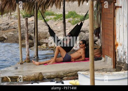 Coppia giovane relax su una amaca in una Casetes Varador vecchio boah house di Ibiza d'Eivissa Baleari Foto Stock