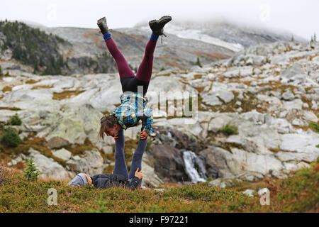 Due amici facendo acro yoga, il Salmone Kokanee Parco del ghiacciaio, British Columbia, Canada Foto Stock