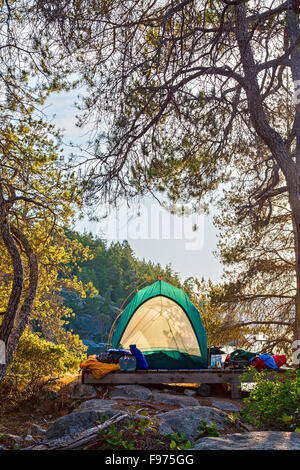 Un kayaker di tenda su West Curme isola si affaccia sull isola di visone nella desolazione del suono del parco marino, British Columbia, Canada. Foto Stock