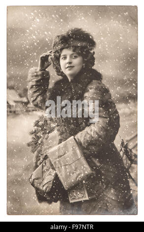 Giovane donna con albero di Natale e regali. Vintage foto con pellicola originale del grano e la sfocatura Foto Stock