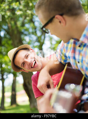 Due giovani uomini felici con la chitarra avendo divertimento outdoor Foto Stock