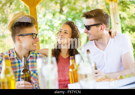 Gruppo di felice gli amici a bere e divertirsi in pub garden Foto Stock