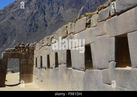 Parete con spazi di stoccaggio e porta alla rovina inca di Ollantaytambo nella Valle Sacra del Perù. Foto Stock