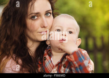 Ritratto di pianto di un bambino che è tenuto da sua madre, all'aperto Foto Stock