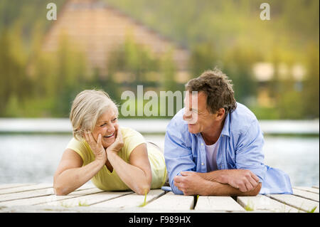 Coppia senior sdraiato e divertirsi sul molo Foto Stock
