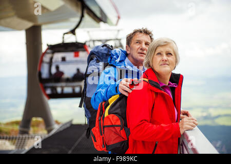 Senior escursionisti giovane è in attesa per la funivia nella stazione di cavo Foto Stock