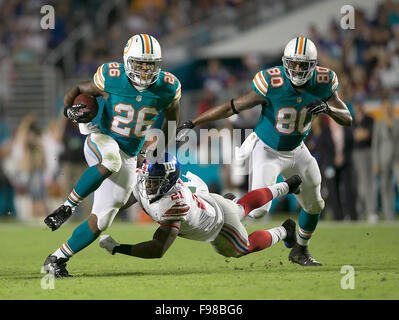 Giardini di Miami, Florida, Stati Uniti d'America. Xiv Dic, 2015. Miami Dolphins running back Lamar Miller (26), scorre su New York Giants libero di sicurezza Landon Collins (21), sul secondo trimestre azione per il suo secondo touchdown del primo semestre durante il gioco NFL lunedì 14 dicembre, 2015 a Sun Life Stadium di Miami. Credito: Bill Ingram/Palm Beach post/ZUMA filo/Alamy Live News Foto Stock