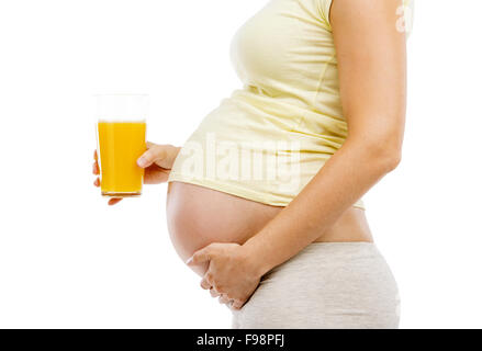Irriconoscibile donna incinta tenendo un bicchiere di succo di arancia, isolati su sfondo bianco Foto Stock