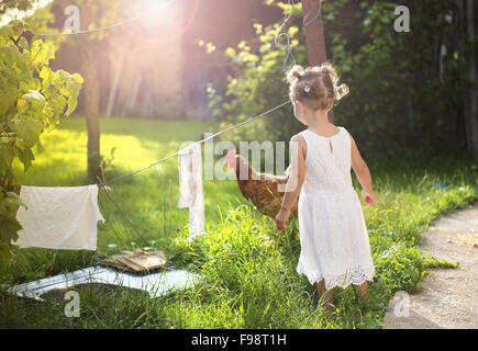 Felice bambina divertendosi nel giardino vicino alla vecchia casa colonica Foto Stock